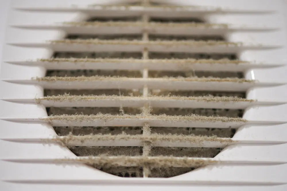 Dirty air ducts with heavy dust buildup on ventilation vent